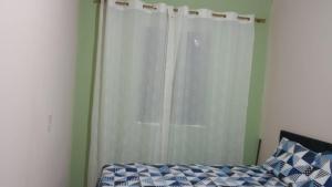穆库热Aluga-se uma casa em Mucugê Bahia的卧室设有白色窗帘的窗户