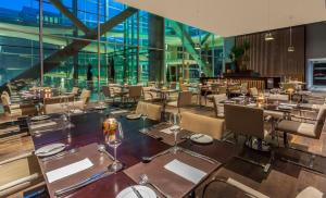 洛斯安赫莱斯Four Points By Sheraton Los Angeles的餐厅设有桌椅和玻璃窗。