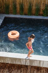 孔波尔塔B.Hostel的儿童在带卫生间的游泳池里玩耍