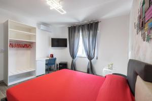 圣多米尼卡Residenza Saint Tropez的一间卧室配有红色的床和一张书桌