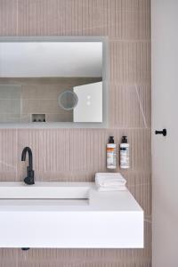 格林波特Hotel Moraine的浴室设有白色水槽和镜子