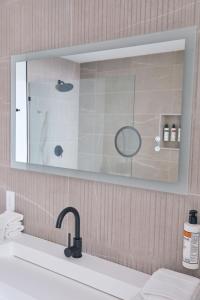 格林波特Hotel Moraine的一间带镜子和水槽的浴室