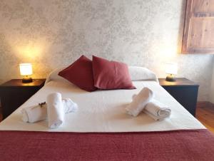 卢戈Casa Aldea de Abaixo的一张带两条毛巾的床和两盏灯