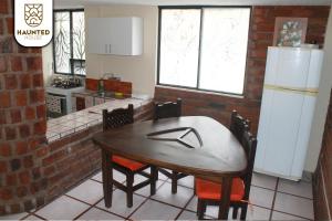 巴尼奥斯Haunted House Casa Vacacional的厨房配有桌椅和冰箱。