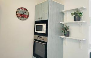 蒂亚斯Apartamento Playa Grande的厨房配有微波炉,墙上挂着时钟