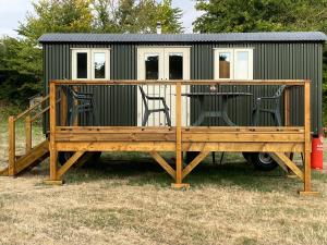TodberThe Old Post Office - Luxurious Shepherds Hut 'Far From the Madding Crowd' based in rural Dorset.的拖车上的小房子,配有桌子和椅子