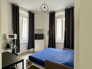 都灵Casa Genova 1/2/3的一间卧室配有蓝色的床、一张书桌和窗户。