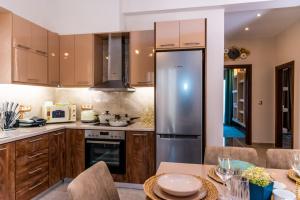 阿里克斯Loula's Villa的厨房配有木制橱柜和不锈钢冰箱。