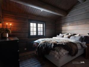 耶卢Luxury log cabing, cross-country ski-in out, familiy getaway in great location的一间卧室配有一张带木墙和窗户的床。