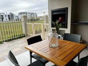 开普敦Mo's Explorer Cape Town Vacation Apartment的阳台上的木桌上花瓶