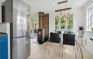 霍尔拜克2 Bedroom Amazing Home In Holbk的厨房配有桌椅和冰箱。