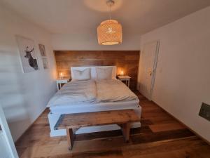 梅谢尼希Charmantes Eifel Ferienhaus an der Schavener Heide的一间卧室配有一张大床和木制床头板