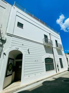马萨夫拉Novecento Room and Breakfast Puglia的前面有拱门的白色建筑