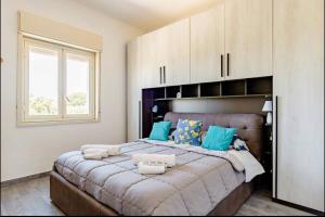 夏卡Il Casello Country House的一间卧室配有一张带蓝色枕头的大床