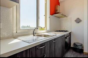 夏卡Il Casello Country House的厨房设有水槽和窗户。