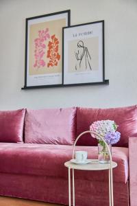 穆卡切沃Best Apartments on Kyryla & Mefodia的客厅里一张粉红色的沙发,上面有两张画框