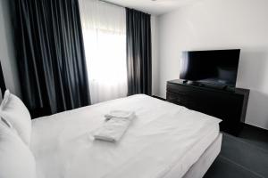 LivezeniConcept Villa的卧室配有白色的床和电视。