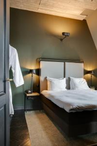 登博斯公爵精品酒店 的一间卧室配有一张带绿色墙壁的床
