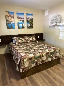 克拉马斯福尔斯Crater Lake Gateway - Hwy 140的卧室配有一张床,墙上挂有绘画作品