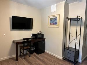 克拉马斯福尔斯Crater Lake Gateway - Hwy 140的一间房间,配有一张桌子和一台墙上的电视