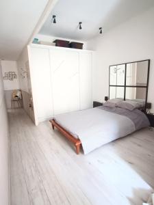 塞特港Appartement Sète proche centre ville的一间卧室配有一张大床和一个白色的橱柜