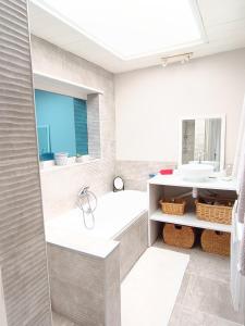 塞特港Appartement Sète proche centre ville的带浴缸和盥洗盆的浴室