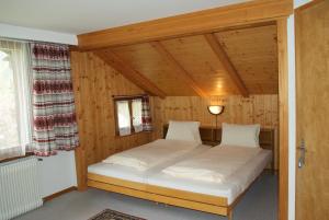 坎德施泰格斯派切尔膳食公寓酒店的木制客房内的一间卧室,配有一张床