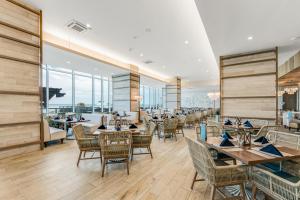 代托纳海滩Daytona Grande Oceanfront Resort的餐厅设有桌椅和窗户。