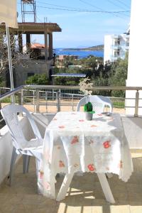 卡萨米尔MyKsamil Apartments的阳台上配有白色的桌椅,享有海景