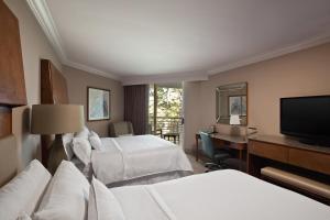 希尔顿黑德岛希尔顿黑德岛威斯汀度假酒店及Spa的酒店客房设有两张床、一张桌子和一台电视。