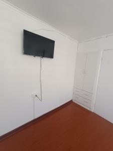 安托法加斯塔Hospedaje Nuevo Amanecer的白色客房,墙上配有平面电视