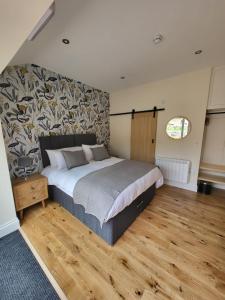 莫珀斯The Star Inn - Harbottle - Near Rothbury - Northumberland的一间卧室设有一张大床,铺有木地板