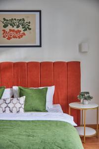 穆卡切沃Best Apartments on Kyryla & Mefodia的一张带红色软垫床头板和绿色枕头的床