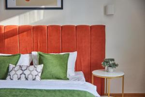穆卡切沃Best Apartments on Kyryla & Mefodia的一张带红色床头板和绿色枕头的床
