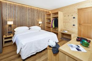 摩德纳迪-坎皮格里奥Hotel Garni dello Sportivo的卧室设有白色的床和木墙