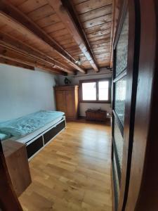 拉沃尔戈Casa Cima的客房设有一张床,铺有木地板。