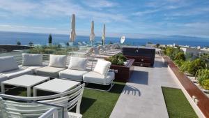 阿德耶Luxury Villa Rebeka - Heated Pool and Jacuzzi的一个带白色桌椅的庭院和大海