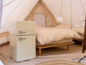 菰野町Nordisk Hygge Circles Ugakei - Vacation STAY 75325v的帐篷内床边的冰箱