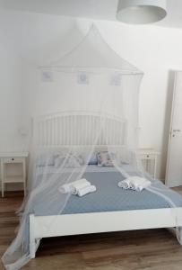 伊斯皮卡IL GUFO DELLA MARZA的一间卧室配有一张带天蓬的白色床