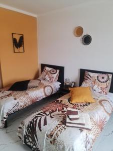 塔拉法尔Deluxe B&B "Casa Alegria", Tarrafal的一间卧室配有两张带色彩缤纷枕头的床