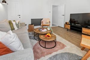 朴次茅斯Cosy & Bright Home with Backyard in Southsea Portsmouth的客厅配有沙发和水果桌