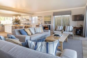 赫曼努斯Seapearl Oceanfront Villa and Cottage的一间带两张沙发的客厅和一间厨房
