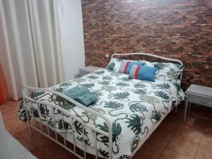 拉皮内达Piso delante de la playa La Pineda con 2 habitaciones的砖墙房间的一个床位