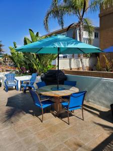 圣地亚哥Luna Azul, cozy condo only steps to Mission Beach! Free Internet的庭院内桌椅和遮阳伞