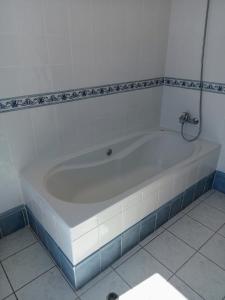 阿科达卡列塔The Artist House的浴室铺有瓷砖地板,配有白色浴缸。