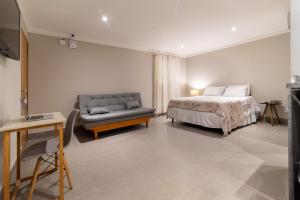 里约热内卢HMG Rio Suítes的一间卧室配有一张床和一张沙发