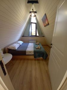 盖贝莱Villa NR in Gabala的小型阁楼卧室设有1张床和1扇窗户。
