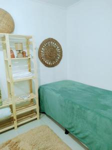 因贝Morada Héstia的一间卧室设有一张绿色的床和一个架子