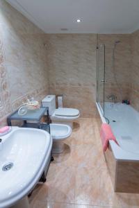 CuchiaAPARTAMENTO COSTA CANTABRIA的浴室设有2个卫生间、水槽和浴缸。