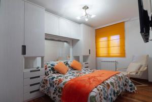CuchiaAPARTAMENTO COSTA CANTABRIA的一间卧室配有带橙色枕头的床
